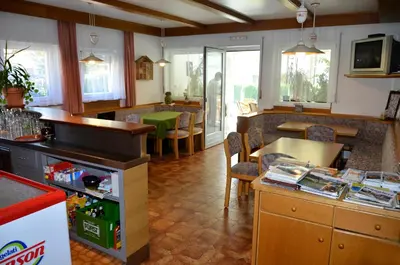 a kitchen with a counter and a table with chairs at Pension Pichler in Chienes