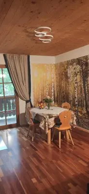 a dining room with a table and chairs and a painting at Winnewieser in Vandoies