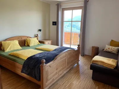 a bedroom with a wooden bed and a window at Kerschbamerhof im Süden Südtirols in Cortaccia