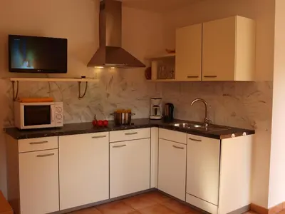 a kitchen with white cabinets and a microwave at Kerschbamerhof im Süden Südtirols in Cortaccia