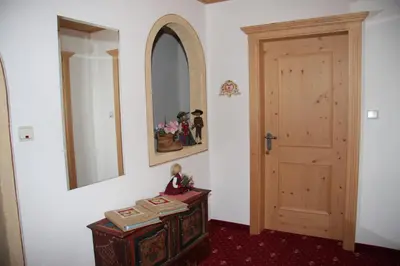 a room with a door and a table with a doll on it at Mair am Hof - Farm - Maso - Bauernhof in San Lorenzo di Sebato