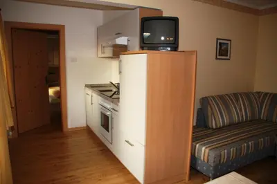 a kitchen with a tv on top of a refrigerator at Mair am Hof - Farm - Maso - Bauernhof in San Lorenzo di Sebato