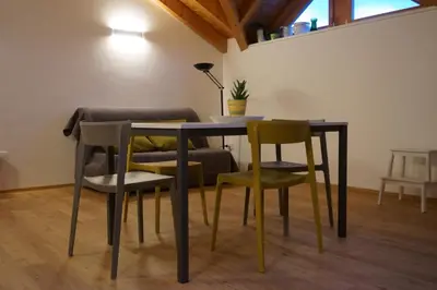 a dining room table with four chairs and a lamp at Agritur Zuveith in Salorno sulla Strada del Vino