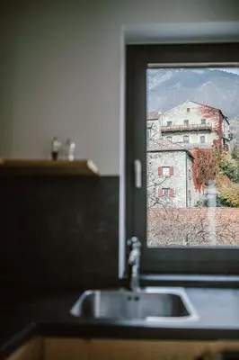 a bathroom sink with a window with an old building at Schloss Auer in Tirolo