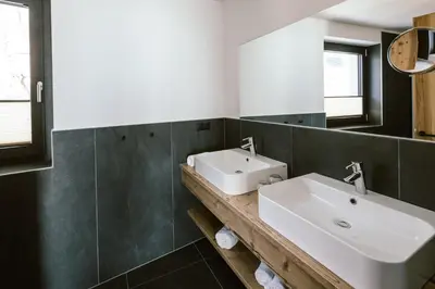 a bathroom with a white sink and a mirror at Schloss Auer in Tirolo