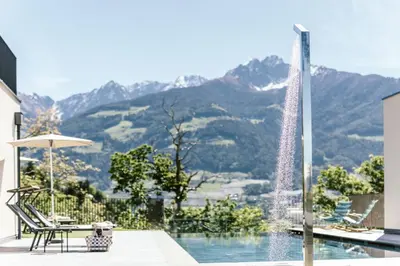 a water fountain in front of a pool with mountains at Schloss Auer in Tirolo