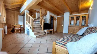 a living room with a bed and a staircase at Appartamento Fiocco Di Neve in Campitello di Fassa