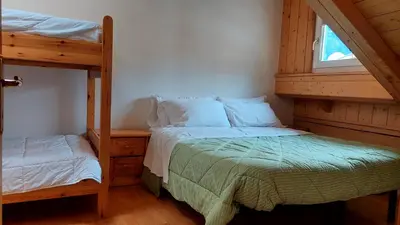 a bedroom with two bunk beds and a window at Appartamento Fiocco Di Neve in Campitello di Fassa