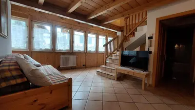 a living room with a couch and a television at Appartamento Fiocco Di Neve in Campitello di Fassa