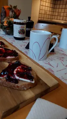 a piece of bread on a cutting board next to a coffee cup at Appartamento Fiocco Di Neve in Campitello di Fassa