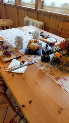 a wooden table with food and utensils on it at Appartamento Fiocco Di Neve in Campitello di Fassa