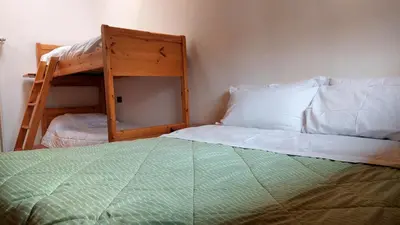 a bedroom with a bunk bed and a bunk bed with a ladder at Appartamento Fiocco Di Neve in Campitello di Fassa