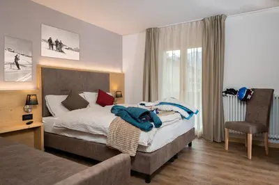 a bedroom with a large bed and a table at GARNI' Margherita in Predazzo