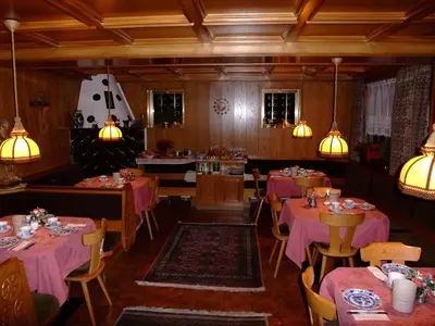 a restaurant with pink tables and chairs and lights at Garnì Conturina in Santa Cristina in Val Gardena