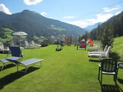 a group of chairs sitting on top of a grass field at Hotel Ronce in Ortisei