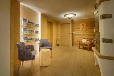 a living room with two chairs and a table at Hotel Ronce in Ortisei