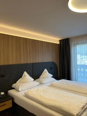 a bedroom with a large bed with white pillows at Hotel Ronce in Ortisei