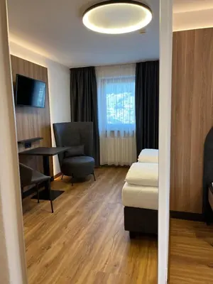 a room with a bed and a desk and a chair at Hotel Ronce in Ortisei
