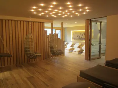 a living room with chairs and lights on the ceiling at Hotel Ronce in Ortisei