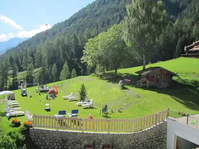 a large green field with a house on a hill at Hotel Ronce in Ortisei