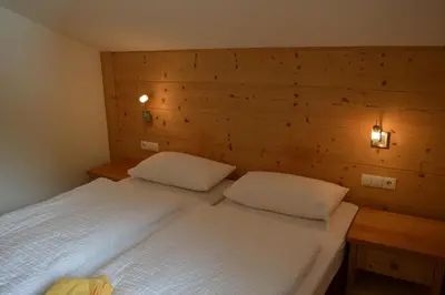 a bedroom with two beds and two lights on the wall at Chalet Regina in Selva di Val Gardena