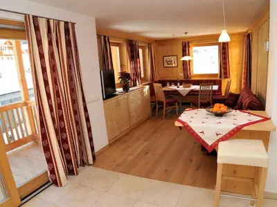 a living room with a table and a dining room at Chalet Regina in Selva di Val Gardena