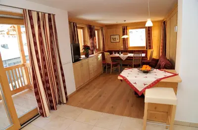 a living room with a table and a dining room at Chalet Regina in Selva di Val Gardena