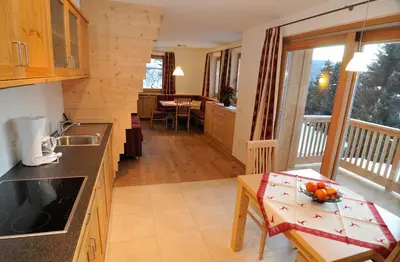 a kitchen with a table with a bowl of fruit on it at Chalet Regina in Selva di Val Gardena