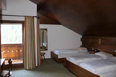 a bedroom with two beds and a window at Villa Luise in Ortisei