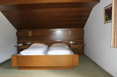 a bed in a room with a wooden headboard at Villa Luise in Ortisei