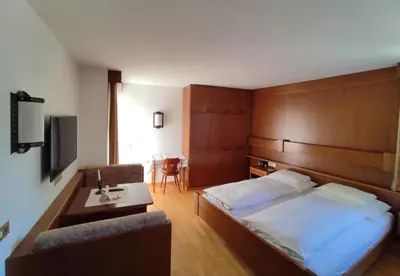 a hotel room with a bed and a desk at Villa Luise in Ortisei