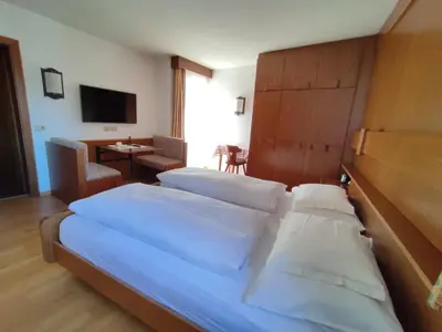 a hotel room with two beds and a tv at Villa Luise in Ortisei