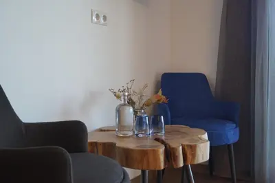 a table with two blue chairs and a vase on it at Gasthof Videgg in Schenna
