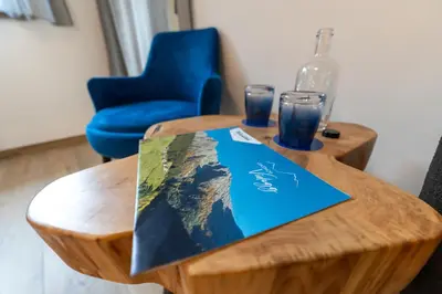 a wooden table with a map and two glasses on it at Gasthof Videgg in Schenna