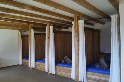 two beds in a room with wooden walls at Gasthof Videgg in Schenna