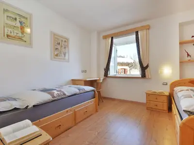 a bedroom with a bed and wooden cabinets and a desk at Apartment Fabio Deluca by Interhome in Vigo di Fassa