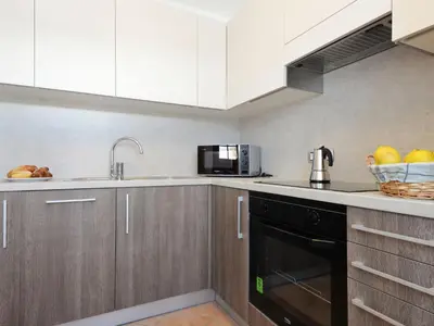 a kitchen with white cabinets and a black dishwasher at Apartment Fabio Deluca by Interhome in Vigo di Fassa
