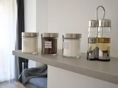 four jars sitting on a shelf in a room at Apartments Sabine K in Merano