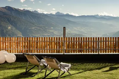 two chairs and a table with a view of mountains at Sweet Dolomiti Sonneck in Maranza