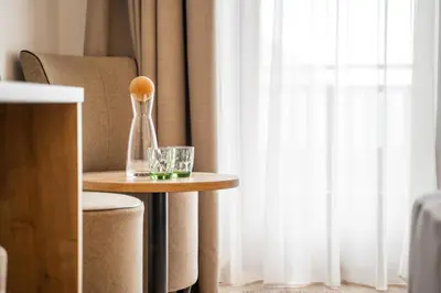 a table with a spoon and a glass on it at Hotel Brunnhofer in Tirolo