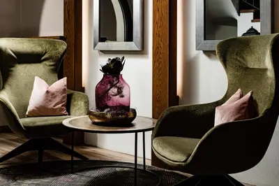 a room with two chairs and a vase on a table at Hotel Brunnhofer in Tirolo
