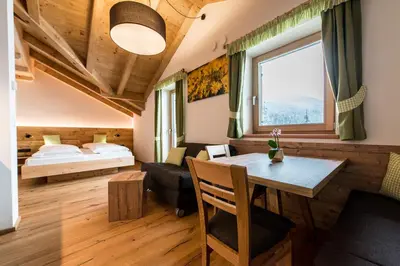 a bedroom with a bed and a table in a room at Rauchenbichlerhof in Brunico