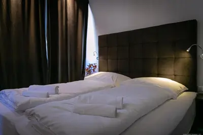 two beds with white pillows sitting next to a window at Apartment Mulino in Merano