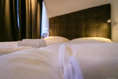 two beds in a room with white sheets at Apartment Mulino in Merano