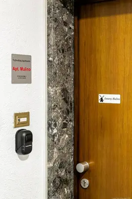 a door with a sign on it next to a wall at Apartment Mulino in Merano