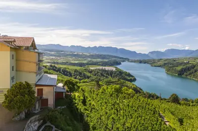 a building on a hill next to a river at Viridis Hotel in Revò