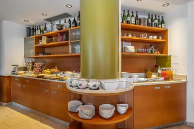 a kitchen with a counter with plates and wine bottles at Viridis Hotel in Revò