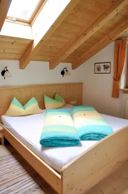 a bed with blue pillows on it in a room at Maurerhof in Racines