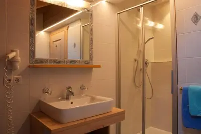a bathroom with a sink and a shower with a mirror at Maurerhof in Racines