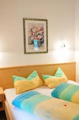 a bedroom with two beds and a picture on the wall at Maurerhof in Racines